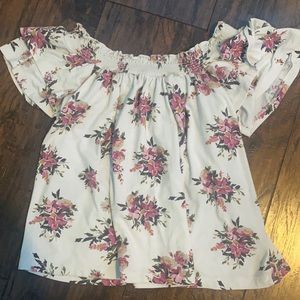 a off the shoulder shirt with little flowers on it